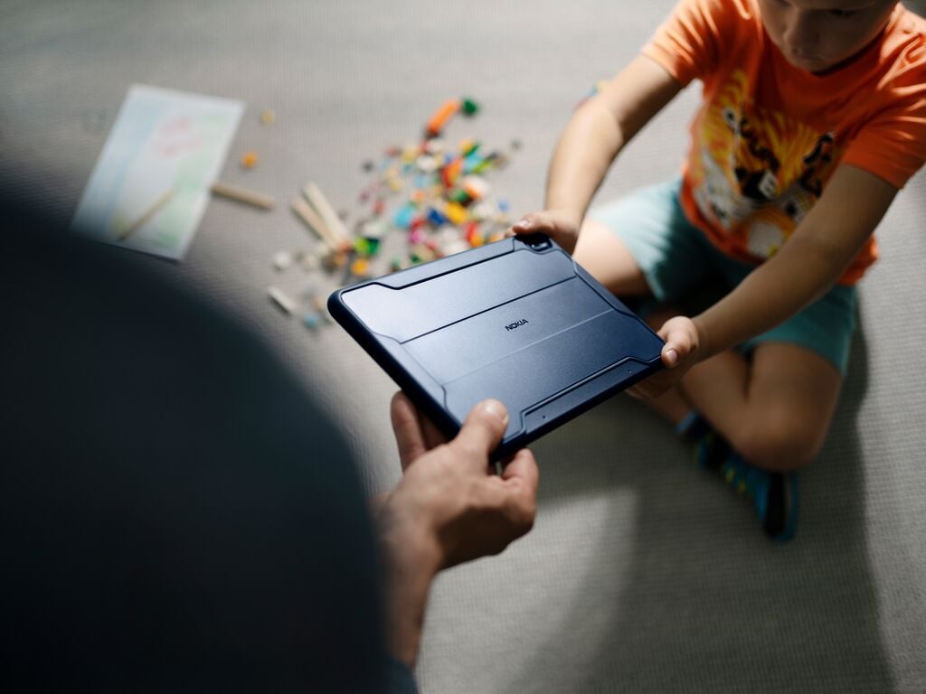 child handing a tablet to adult