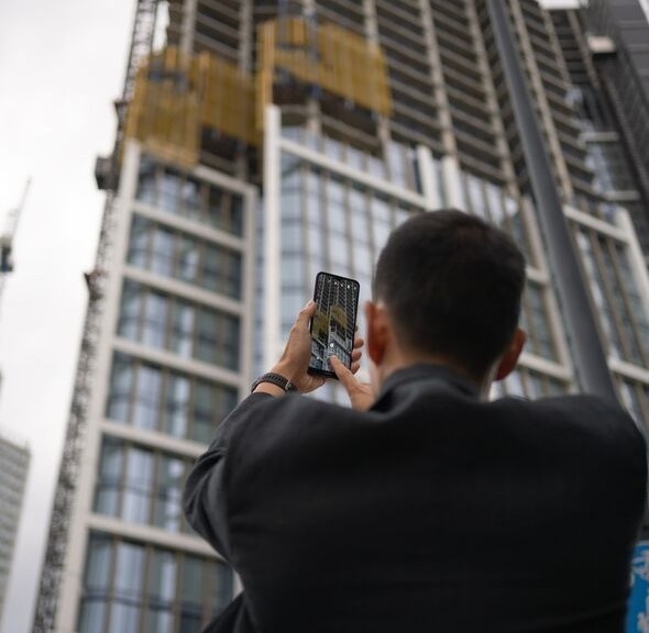 man taking photo of skyscraper