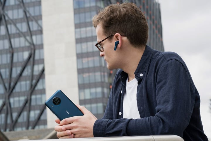 man with earbuds on and a phone in hand