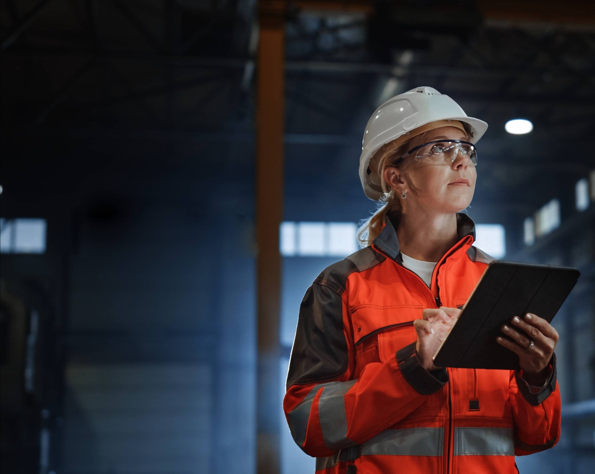 construction worker in a dark warehouse with tablet